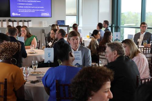 Attendees are all gathered around different tables and are engaged in conversations