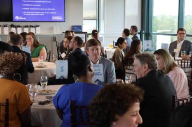 Cocktails and Conversations attendees sit around different tables engaged in conversation
