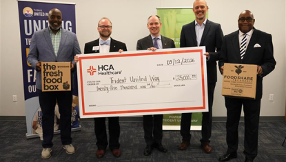 Tory Liferidge - Co-Executive Director at Grace Impact,  DJ Hampton - President & CEO of Trident United Way, Jeff Wilson - CEO of HCA Healthcare Trident Hospital Jeff Taylor, CEO of HCA Healthcare Summerville Hospital, Rufus McDonald - Financial Secretary at Four Rivers Outreach Community Development Corporation hold up the donation check and FoodShare Boxes.