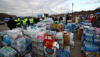 Large pallets with water bottles are stacked for a disaster relief effort.