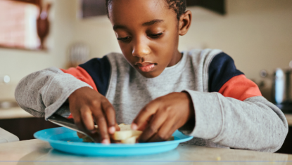 A boy is eating a sandwich on a plate. Below reads THE CARE FUND, and there are logos for partners Lowcountry Food Bank, Coastal Community Foundation, Trident United Way and Palmetto Good Will
