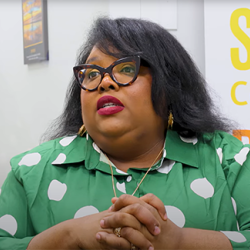 Racheal sitting in front of the camera talking to someone behind it.